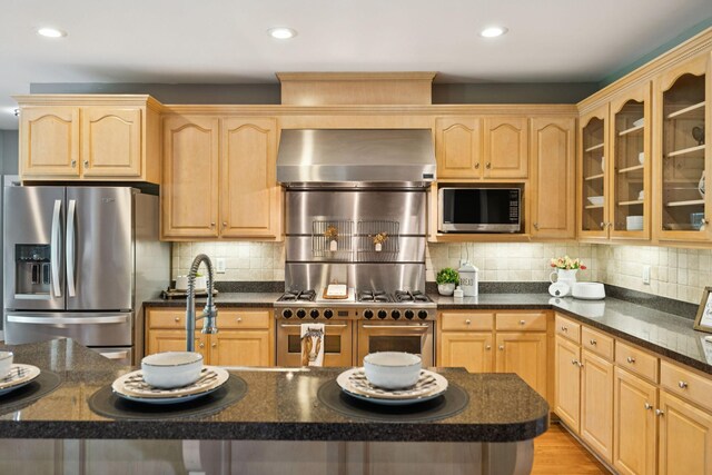1387 Floyd Rd, Eagleville, TN 37060 - kitchen featuring wall chimney exhaust hood, appliances with stainless steel finishes, light brown cabinets, glass insert cabinets, and recessed lighting