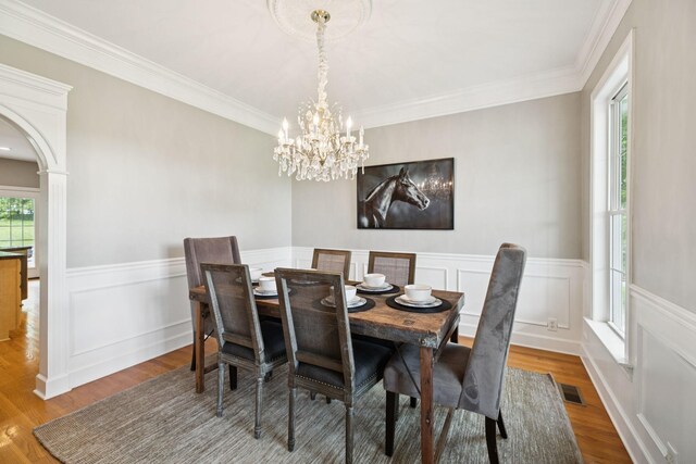 1387 Floyd Rd, Eagleville, TN 37060 - dining space featuring wainscoting, arched walkways, a chandelier, wood finished floors, and ornamental molding