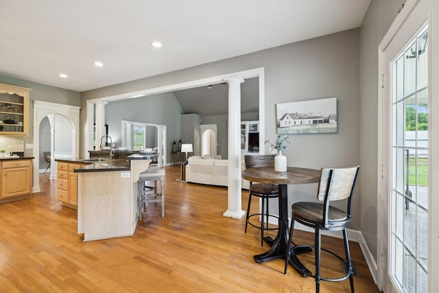 1387 Floyd Rd, Eagleville, TN 37060 - kitchen with light brown cabinetry, a breakfast bar, plenty of natural light, dark countertops, and recessed lighting