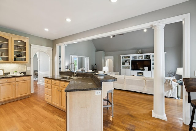 1387 Floyd Rd, Eagleville, TN 37060 - kitchen featuring ornate columns, light brown cabinets, a kitchen bar, vaulted ceiling, and arched walkways