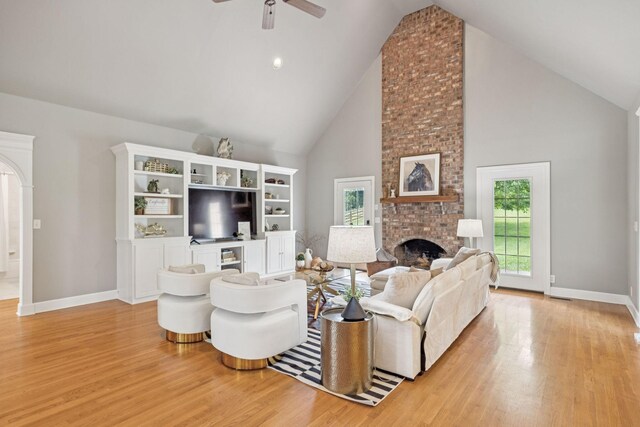 1387 Floyd Rd, Eagleville, TN 37060 - living room with high vaulted ceiling, a brick fireplace, light wood-type flooring, and a ceiling fan