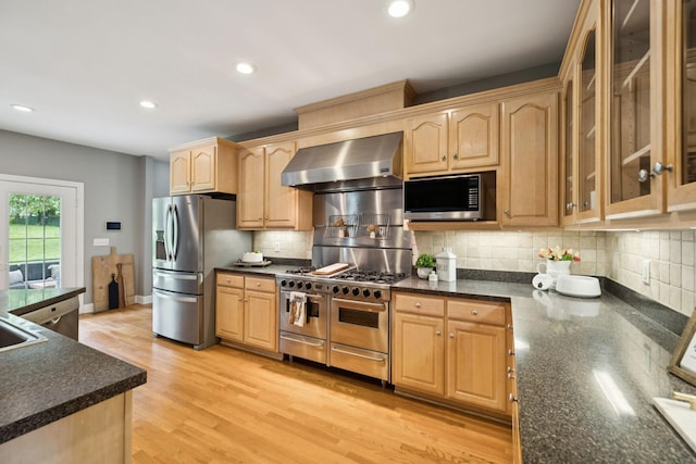 1387 Floyd Rd, Eagleville, TN 37060 - kitchen with wall chimney exhaust hood, stainless steel appliances, light brown cabinetry, glass insert cabinets, and decorative backsplash