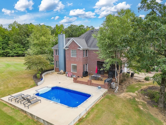 118 Stonebridge, Selmer, TN 38375 - rear view of house featuring a patio, a lawn, an outdoor pool, a chimney, and brick siding