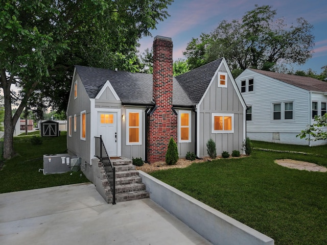 410 Campbell Ave, Tullahoma, TN 37388 - view of front of home featuring board and batten siding, a chimney, a lawn, and roof with shingles