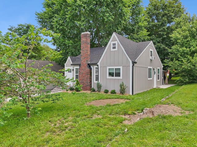 410 Campbell Ave, Tullahoma, TN 37388 - view of front facade with a chimney, board and batten siding, a front yard, and a shingled roof