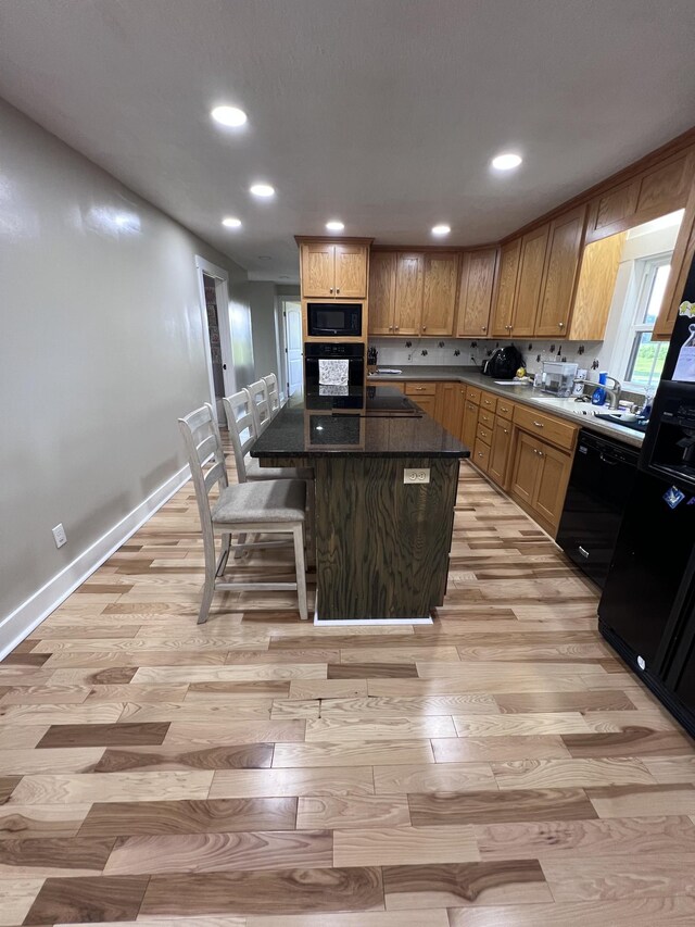 11 Jess Long Ln, Hillsboro, TN 37342 - kitchen featuring black appliances, light wood finished floors, recessed lighting, a kitchen island, and a breakfast bar