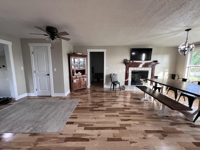 11 Jess Long Ln, Hillsboro, TN 37342 - dining area with wood finished floors, a textured ceiling, a tiled fireplace, ceiling fan, and a chandelier