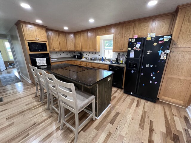 11 Jess Long Ln, Hillsboro, TN 37342 - kitchen featuring black appliances, light wood-style flooring, a breakfast bar, recessed lighting, and a kitchen island