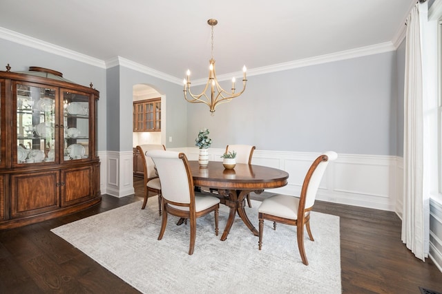 6826 Falls Ridge Ln, College Grove, TN 37046 - dining space with a chandelier, ornamental molding, a wainscoted wall, dark wood-style flooring, and arched walkways