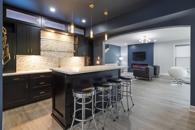 6826 Falls Ridge Ln, College Grove, TN 37046 - bar area with arched walkways, decorative backsplash, wood finished floors, decorative light fixtures, and recessed lighting
