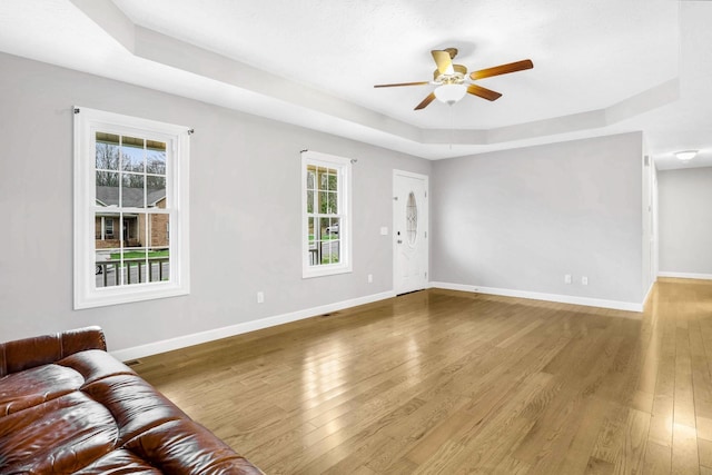 458 Robins Trl, Westmoreland, TN 37186 - unfurnished living room featuring a raised ceiling, ceiling fan, and wood finished floors