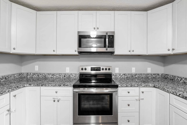 458 Robins Trl, Westmoreland, TN 37186 - kitchen with stainless steel appliances, white cabinets, and light stone counters