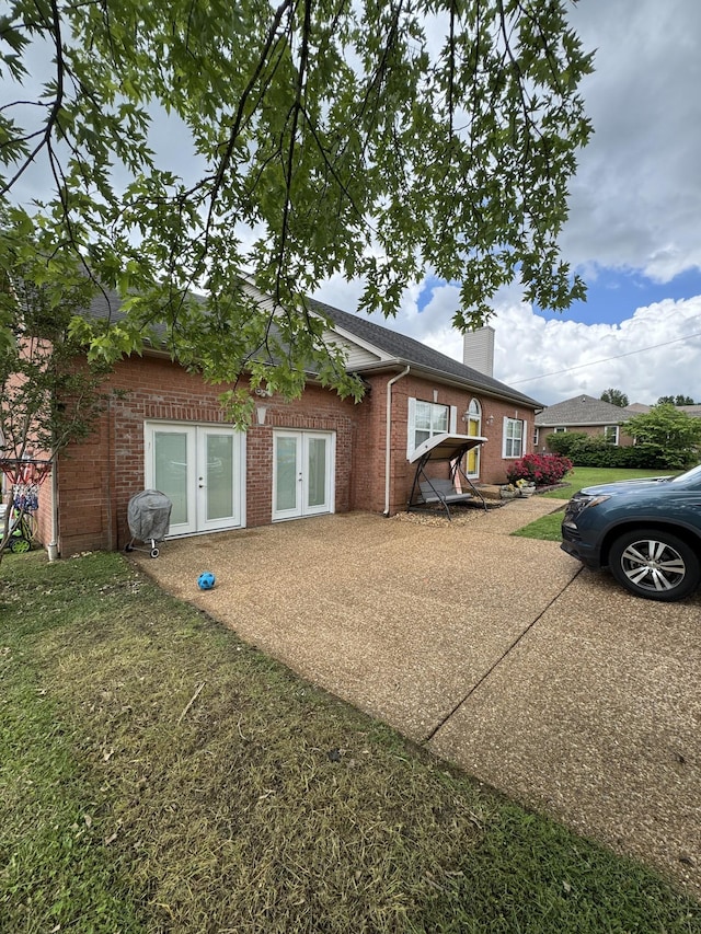 1114 Lea Cir, Lebanon, TN 37087 - view of front of house with french doors, a chimney, brick siding, and a front yard