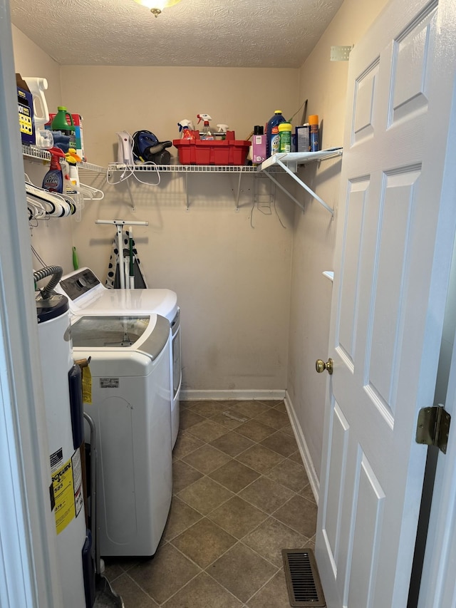 1114 Lea Cir, Lebanon, TN 37087 - laundry room featuring water heater, washer and dryer, a textured ceiling, and dark tile patterned flooring