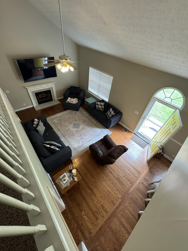 1114 Lea Cir, Lebanon, TN 37087 - living area featuring lofted ceiling, a textured ceiling, a ceiling fan, wood finished floors, and a fireplace with flush hearth