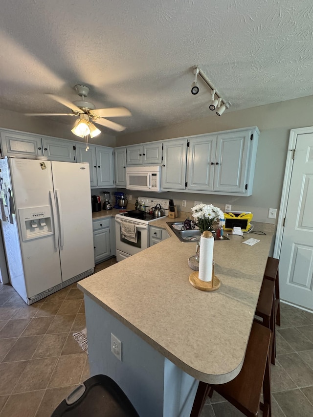 1114 Lea Cir, Lebanon, TN 37087 - kitchen with white appliances, a peninsula, a textured ceiling, light countertops, and track lighting