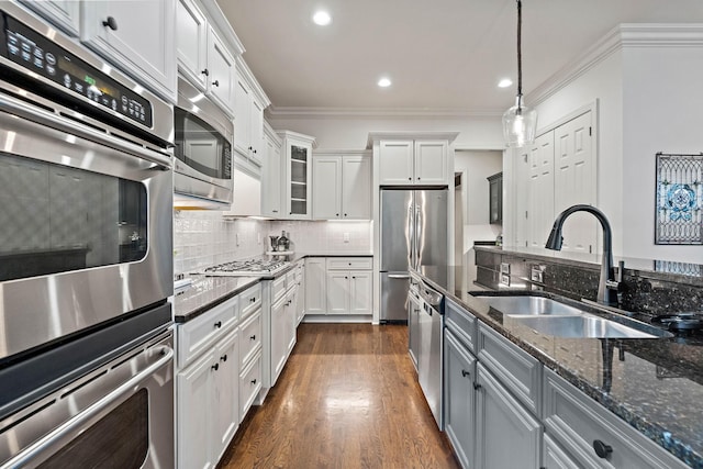 104 Majestic Ln, Franklin, TN 37064 - kitchen featuring appliances with stainless steel finishes, crown molding, white cabinetry, decorative light fixtures, and dark wood-style flooring