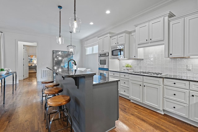 104 Majestic Ln, Franklin, TN 37064 - kitchen featuring stainless steel appliances, ornamental molding, a breakfast bar area, dark wood-style floors, and decorative backsplash