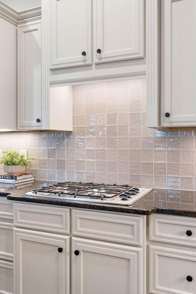 104 Majestic Ln, Franklin, TN 37064 - kitchen with stainless steel gas cooktop, tasteful backsplash, dark stone countertops, and white cabinetry