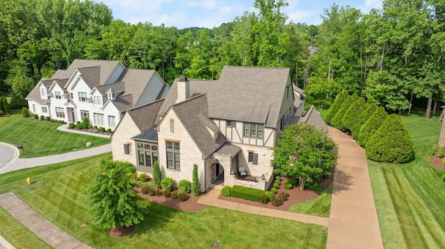 4310 Kings Camp Ct, Arrington, TN 37014 - view of front of property featuring stone siding, a chimney, a shingled roof, a front lawn, and a patio area
