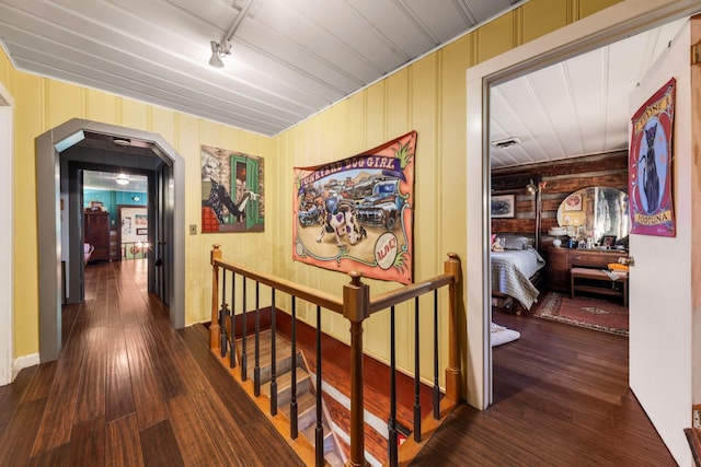 7139 Kingston Rd, Fairview, TN 37062 - corridor featuring arched walkways, dark wood-type flooring, rail lighting, and an upstairs landing