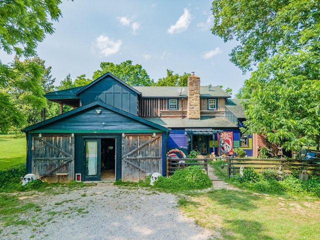 7139 Kingston Rd, Fairview, TN 37062 - view of front of home featuring board and batten siding, a barn, a chimney, and an outdoor structure