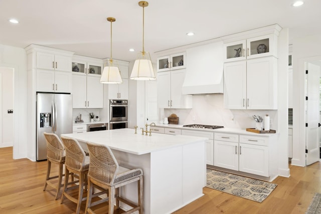 973 Hall Cemetery Rd, Burns, TN 37029 - kitchen featuring appliances with stainless steel finishes, recessed lighting, light wood-style flooring, a center island with sink, and backsplash