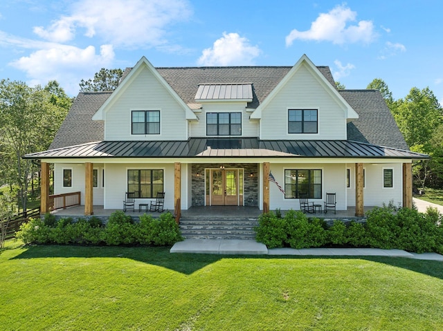 973 Hall Cemetery Rd, Burns, TN 37029 - modern farmhouse featuring a standing seam roof, roof with shingles, a metal roof, a front yard, and covered porch