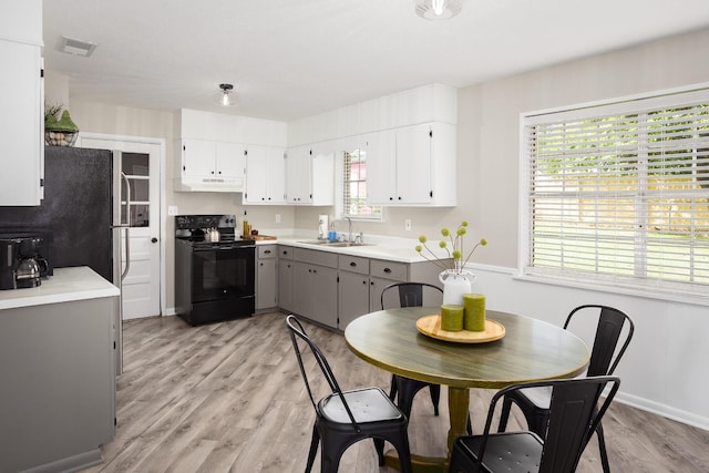 1808 Nassau Blvd, Florence, AL 35630 - kitchen with black / electric stove, under cabinet range hood, gray cabinets, light wood-style floors, and light countertops