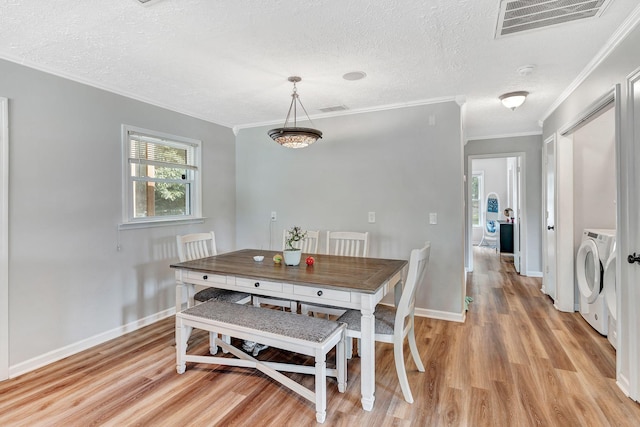 141 Springbrook Pl, Joelton, TN 37080 - dining area featuring washing machine and clothes dryer, light wood-style flooring, ornamental molding, and a textured ceiling