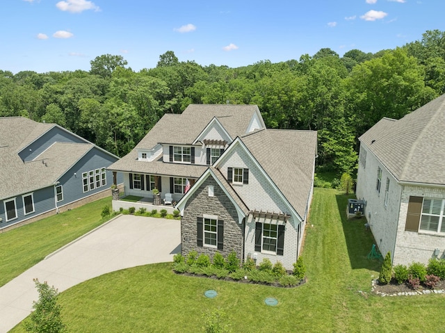 5128 Terravista Ln, Franklin, TN 37064 - view of front of home featuring stone siding, covered porch, a front lawn, and a forest view