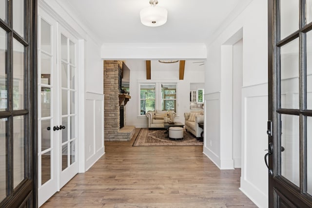 5128 Terravista Ln, Franklin, TN 37064 - entryway featuring french doors, light wood-type flooring, ornamental molding, a fireplace, and beam ceiling