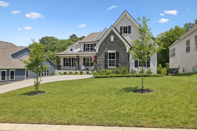5128 Terravista Ln, Franklin, TN 37064 - view of front facade featuring covered porch, stone siding, and a front lawn