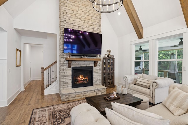 5128 Terravista Ln, Franklin, TN 37064 - living room featuring high vaulted ceiling, wood-type flooring, beamed ceiling, a stone fireplace, and a chandelier