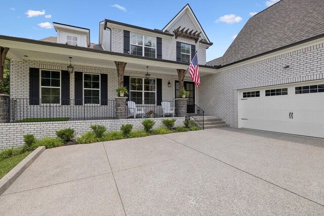 5128 Terravista Ln, Franklin, TN 37064 - view of front of house featuring covered porch, brick siding, concrete driveway, and a garage