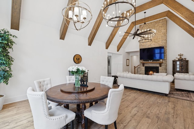 5128 Terravista Ln, Franklin, TN 37064 - dining space with a chandelier, beamed ceiling, wood finished floors, high vaulted ceiling, and a fireplace
