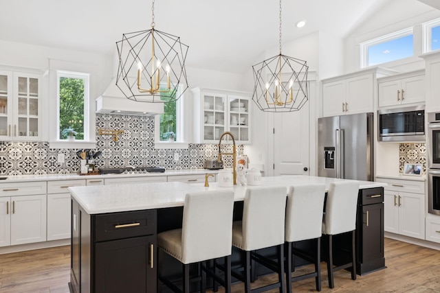 5128 Terravista Ln, Franklin, TN 37064 - kitchen featuring appliances with stainless steel finishes, a chandelier, light countertops, white cabinets, and vaulted ceiling