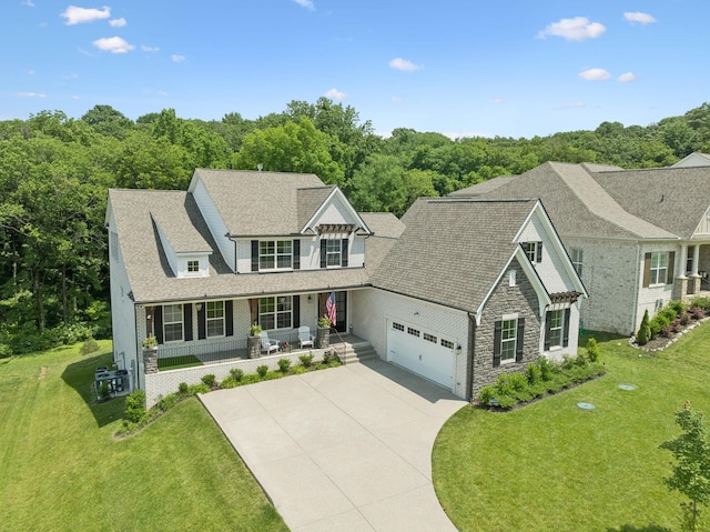 5128 Terravista Ln, Franklin, TN 37064 - view of front of property with covered porch, stone siding, a front yard, driveway, and a garage
