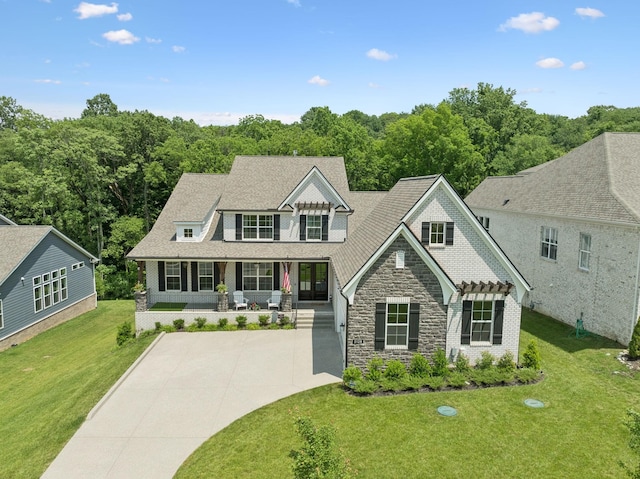5128 Terravista Ln, Franklin, TN 37064 - shingle-style home with stone siding, a porch, a front yard, and concrete driveway