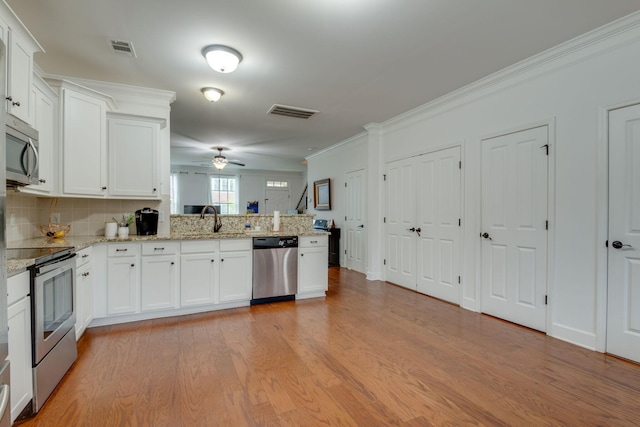 2003 Rural Plains Cir, Franklin, TN 37064 - kitchen featuring stainless steel appliances, a peninsula, light wood-style flooring, a ceiling fan, and white cabinetry