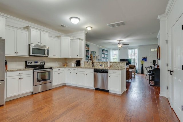 2003 Rural Plains Cir, Franklin, TN 37064 - kitchen featuring stainless steel appliances, a peninsula, open floor plan, white cabinets, and crown molding