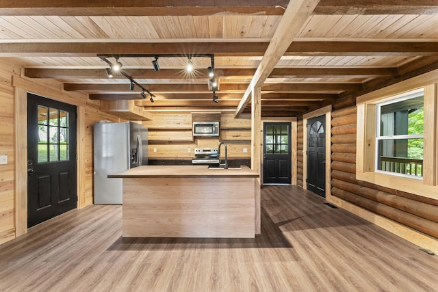 7121 Robinson Dr, Fairview, TN 37062 - kitchen featuring appliances with stainless steel finishes, track lighting, a wooden ceiling with exposed beams, dark wood-type flooring, and log walls