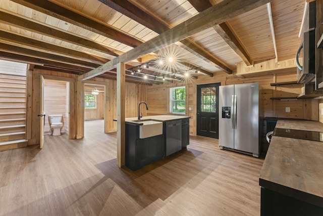 7121 Robinson Dr, Fairview, TN 37062 - kitchen featuring stainless steel appliances, wood walls, a wood ceiling with exposed beams, light wood finished floors, and healthy amount of natural light
