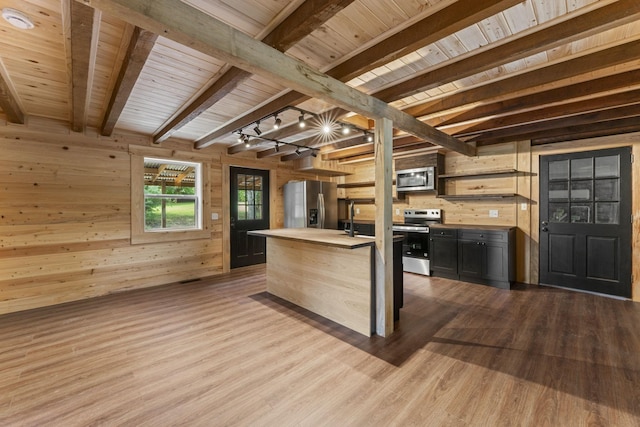 7121 Robinson Dr, Fairview, TN 37062 - kitchen with stainless steel appliances, wood walls, light countertops, wood finished floors, and a wood ceiling with exposed beams