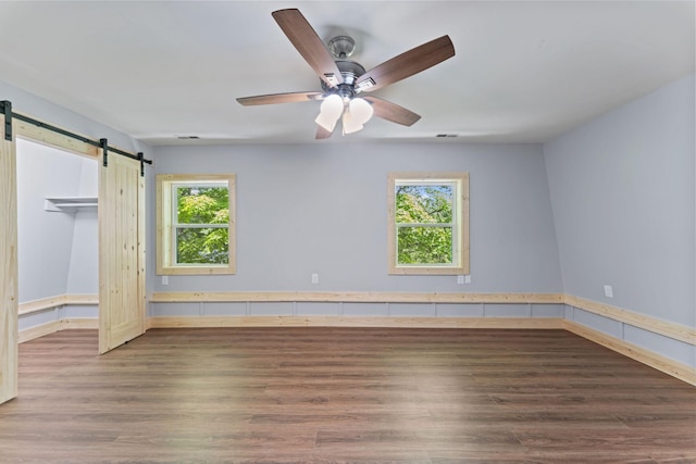 7121 Robinson Dr, Fairview, TN 37062 - unfurnished bedroom with a barn door, wood finished floors, and a ceiling fan