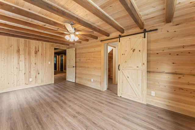 7121 Robinson Dr, Fairview, TN 37062 - unfurnished room with wooden walls, ceiling fan, a wood ceiling with exposed beams, a barn door, and wood finished floors