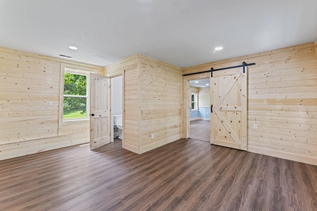 7121 Robinson Dr, Fairview, TN 37062 - unfurnished room featuring wood walls, a barn door, dark wood-type flooring, and recessed lighting