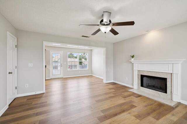 1882 Portway Rd, Spring Hill, TN 37174 - unfurnished living room featuring light wood-style floors, a ceiling fan, and a high end fireplace