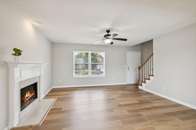 1882 Portway Rd, Spring Hill, TN 37174 - unfurnished living room featuring ceiling fan, a premium fireplace, light wood-style floors, and stairway
