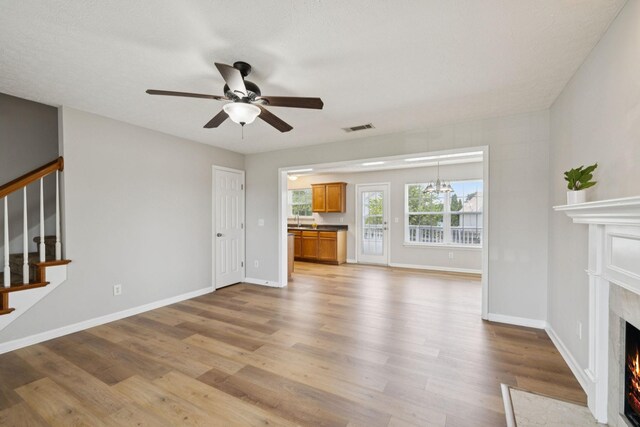 1882 Portway Rd, Spring Hill, TN 37174 - unfurnished living room featuring a premium fireplace, a ceiling fan, light wood-style flooring, and stairway